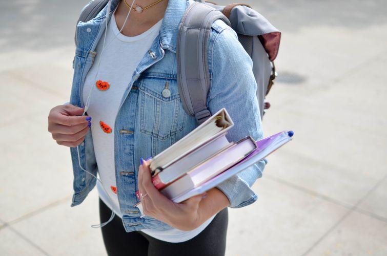 Student holding books and binder