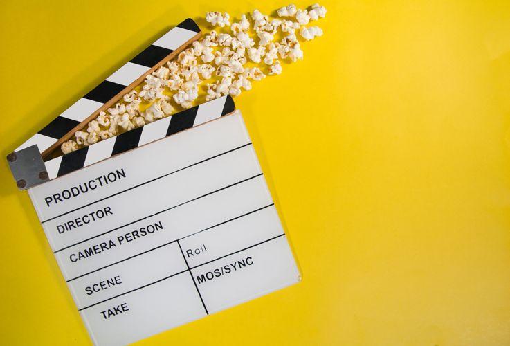 movie film with popcorn on yellow background